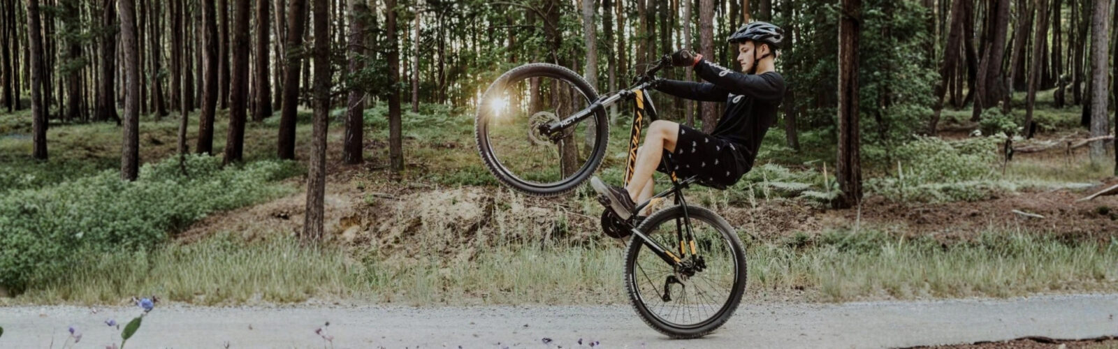 Biciklis akrobatikus mutatvány erdei ösvényen.